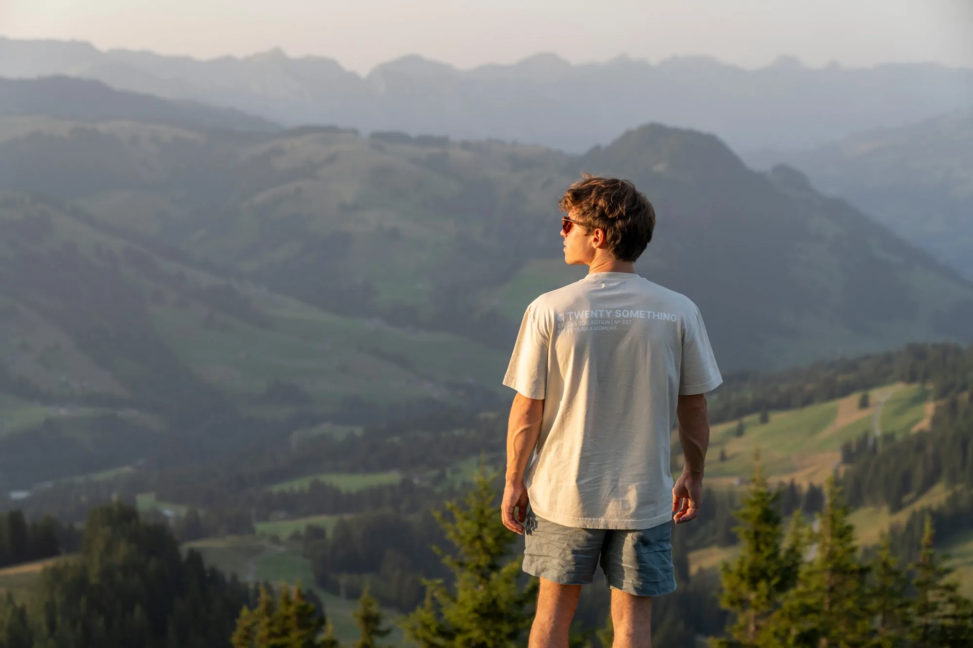 Mann im Twenty Tee blickt im Abendlicht über die Voralpen